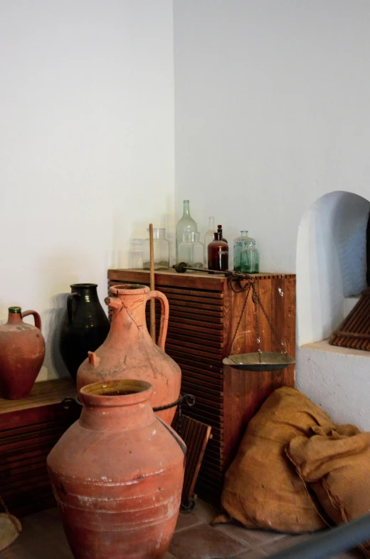 the corner of the room has a large jar and two other items