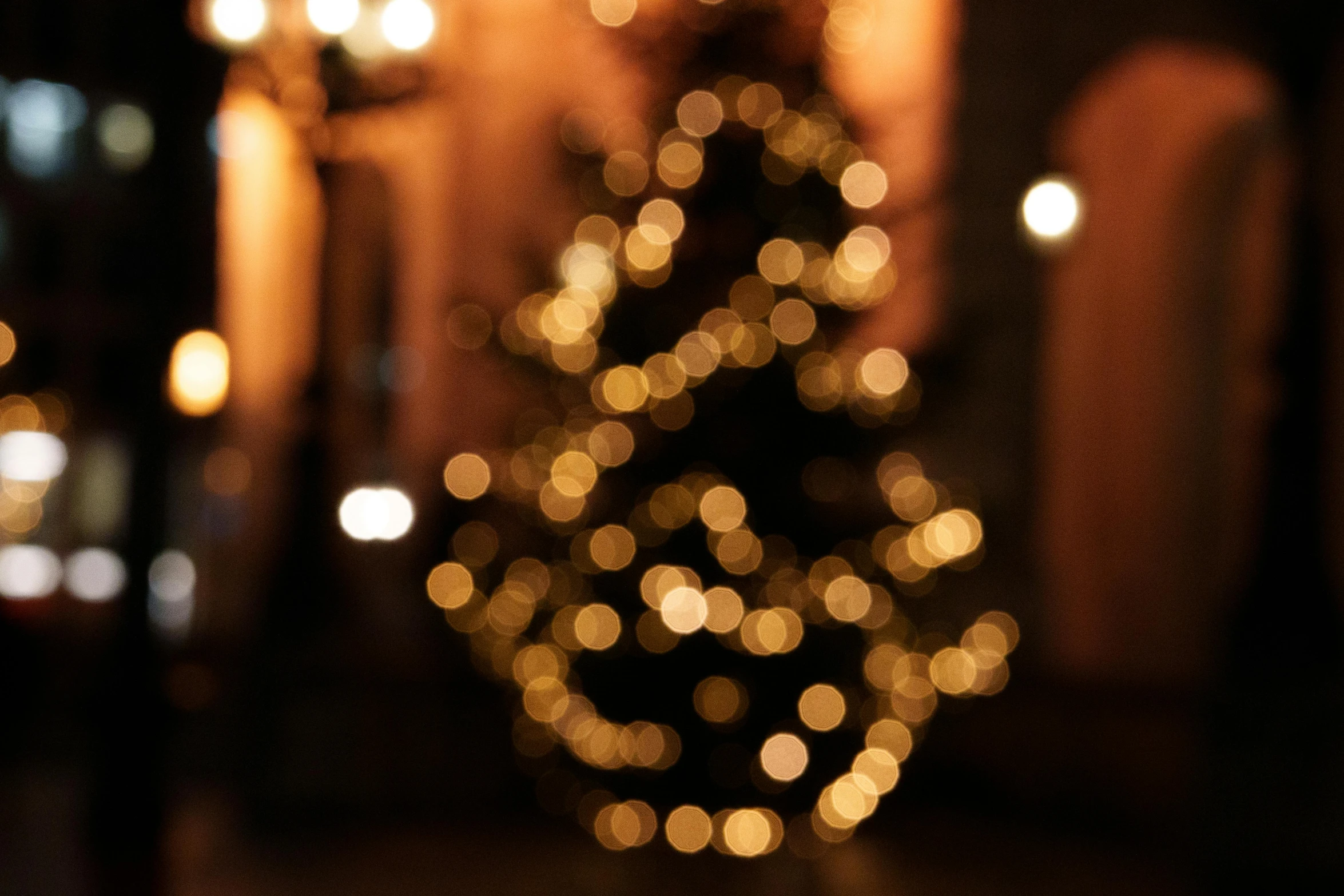 the blurry light of a christmas tree against the dark background