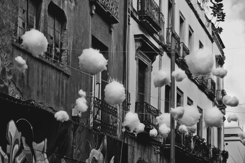 black and white po of clouds coming from an apartment building