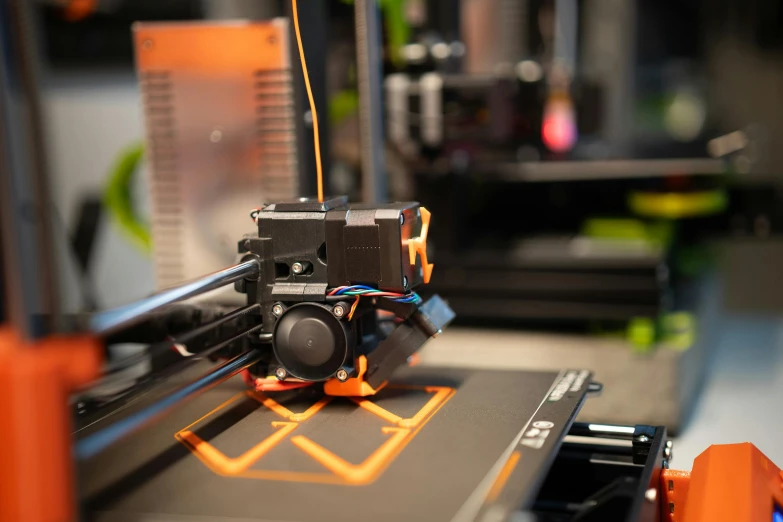 3d printing machine with camera attached in orange frame