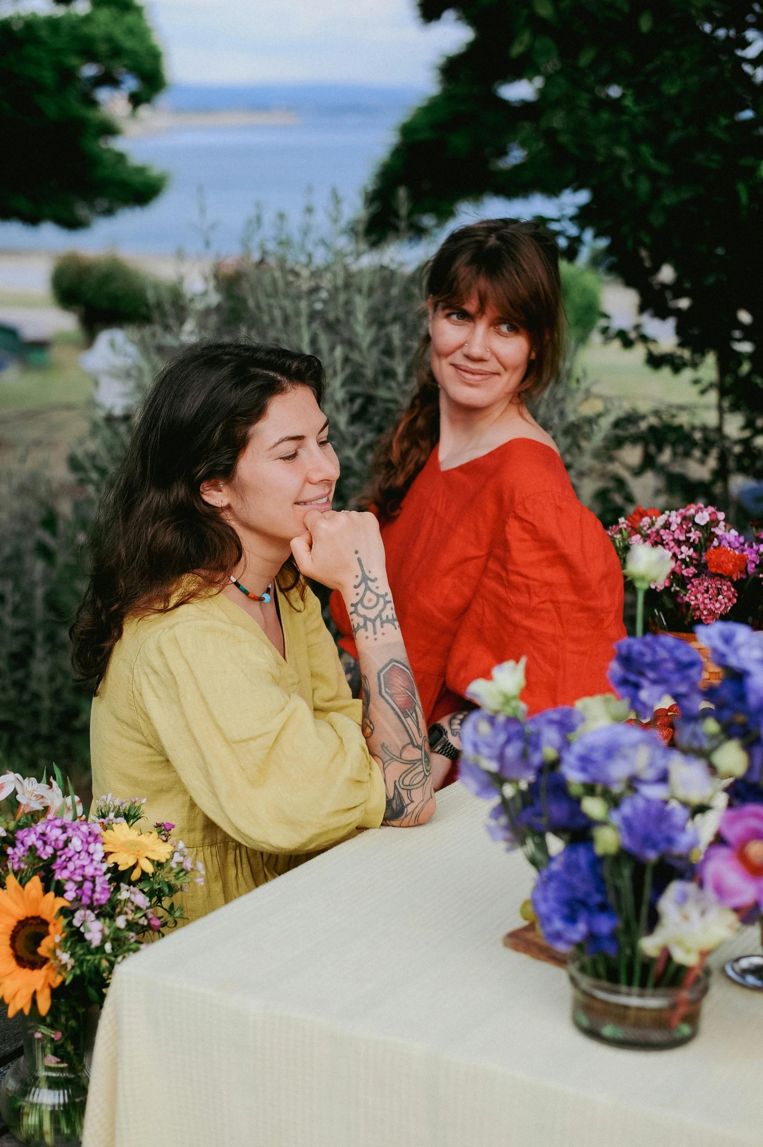 two women sitting at a table, smiling for the camera