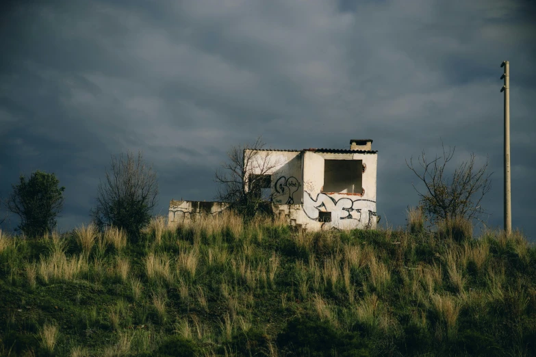 a building on a hill covered in weeds