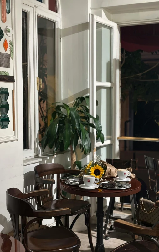 a set of wooden chairs and table with sunflower on the top