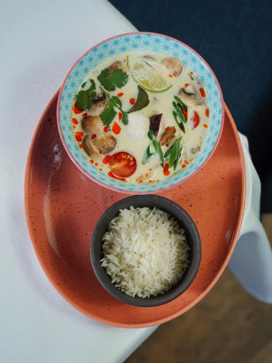 a bowl of soup next to a plate of rice