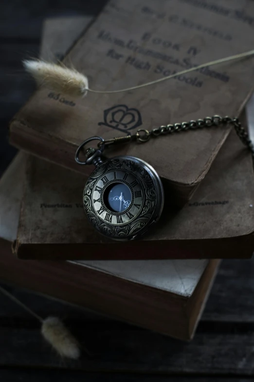 a pocket watch on top of some books