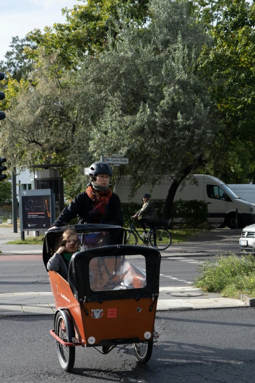 a family riding in a small carriage in the street