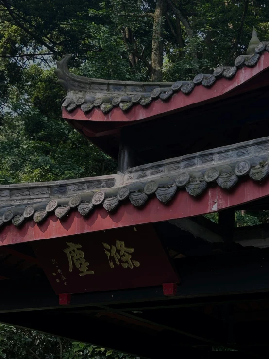 a red roof sitting next to a building with oriental writing