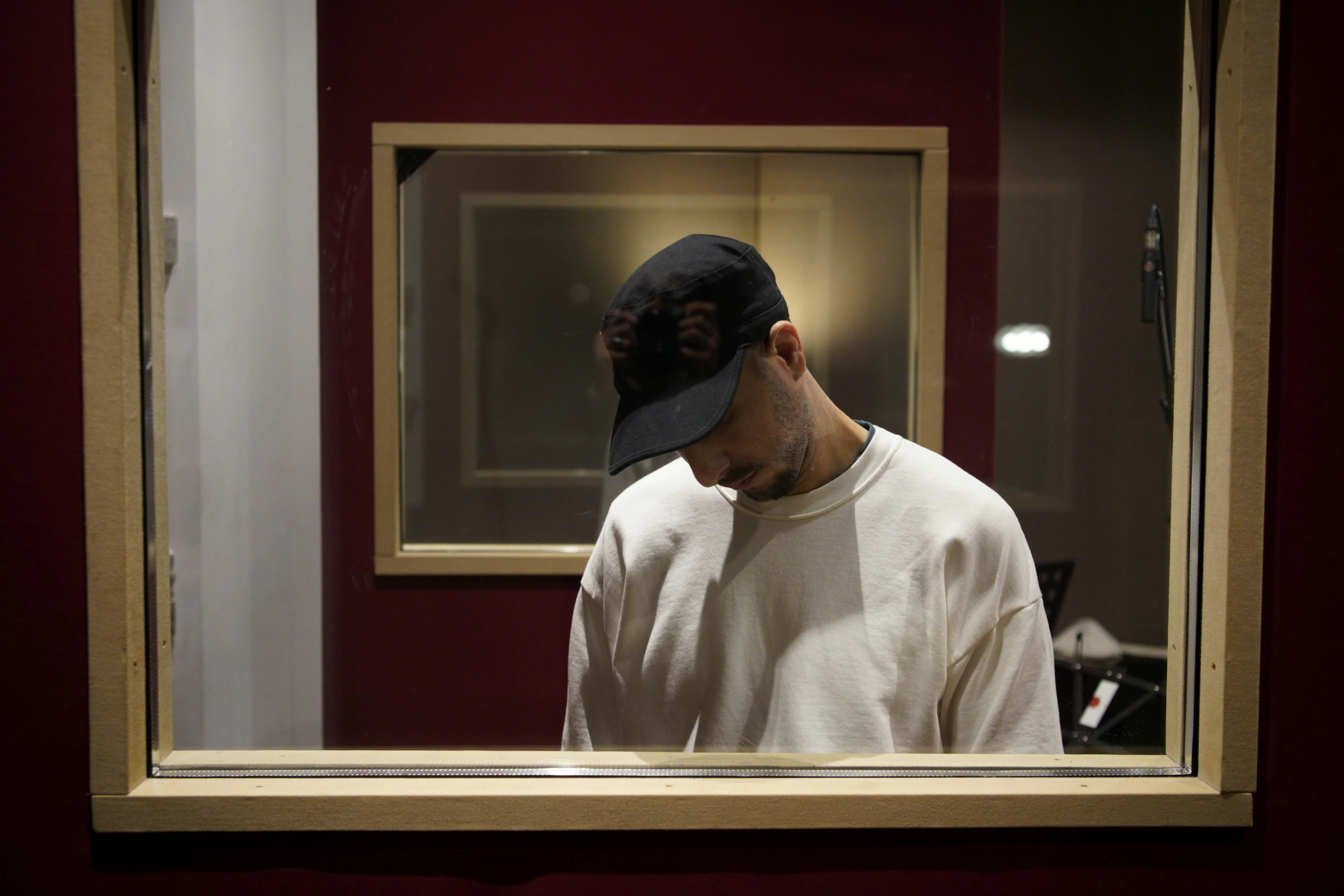 a man with a baseball cap looking in a mirror