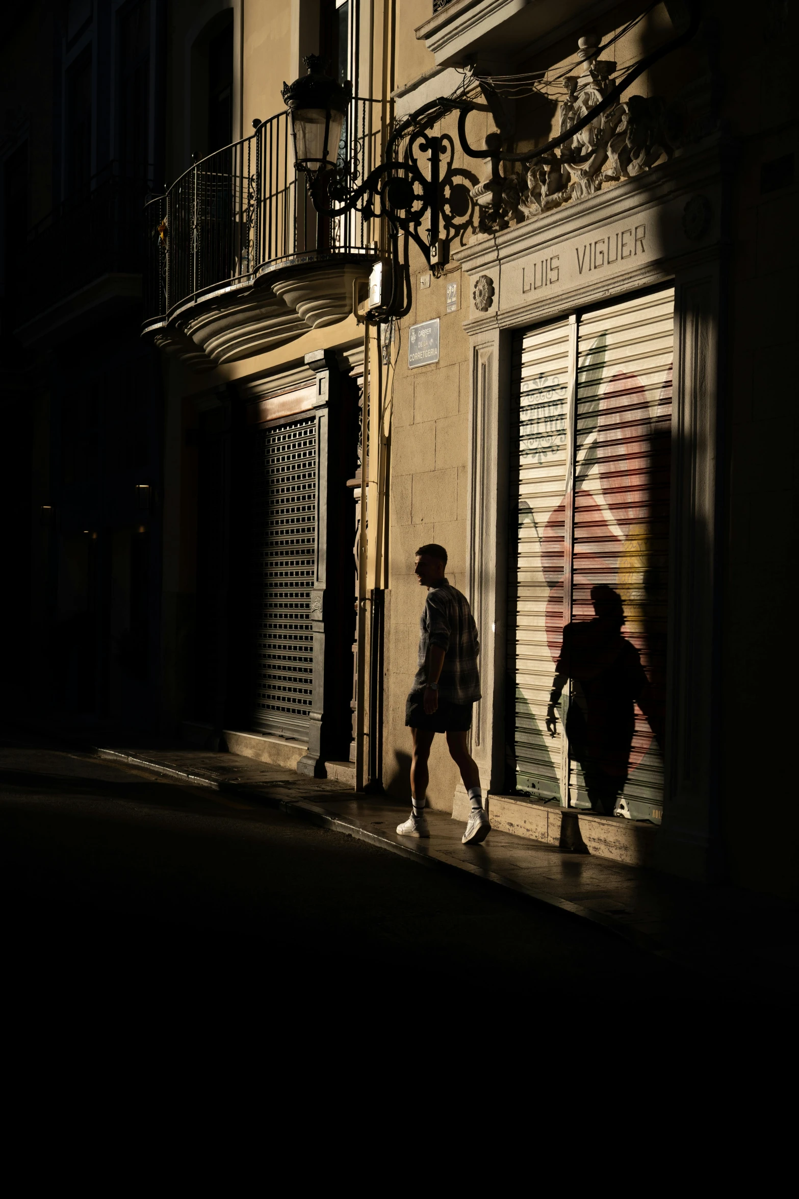 two people are walking down the sidewalk next to buildings