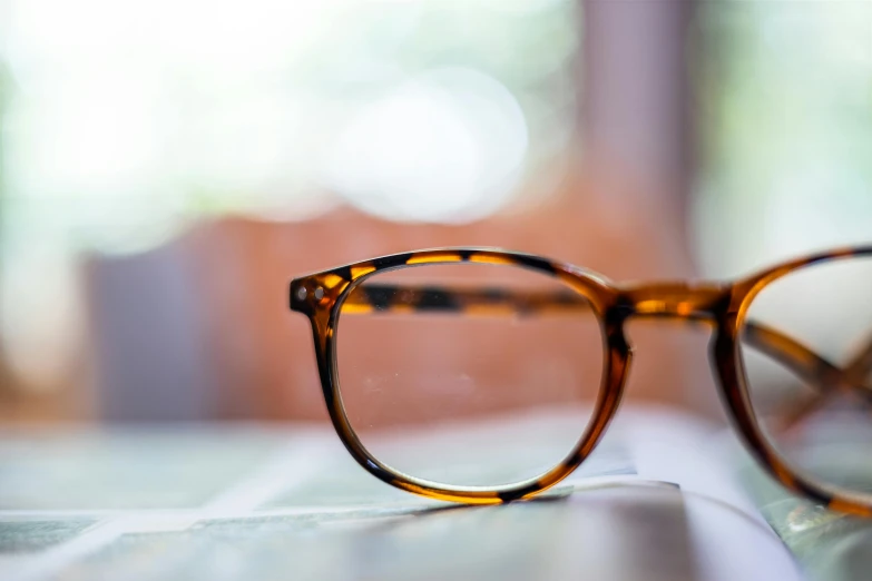 a pair of glasses resting on top of a white keyboard