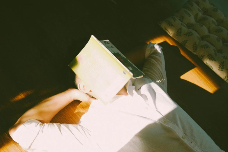 the person is holding an empty book as they lie in a bed