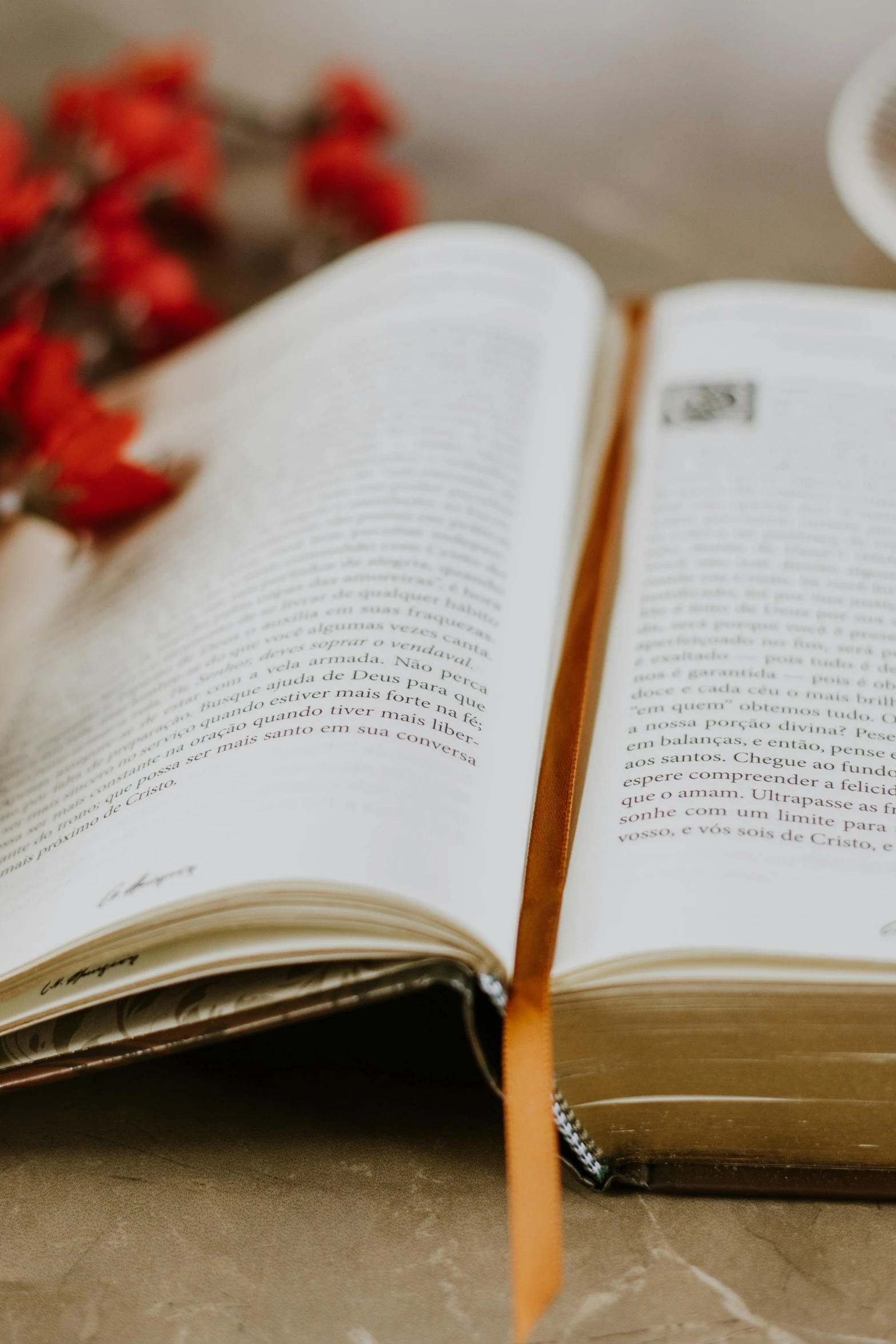 an open book with some flowers sitting on the table