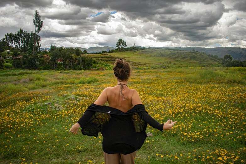 a woman in an open field with flowers