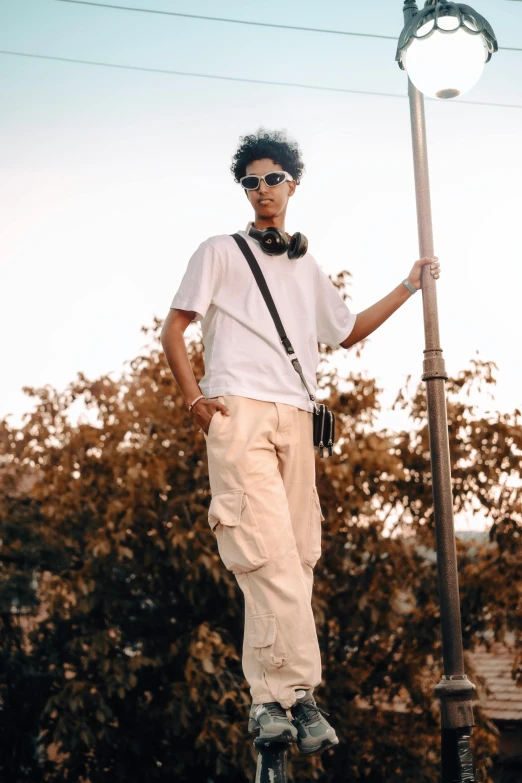 the man is standing on top of a lamp post