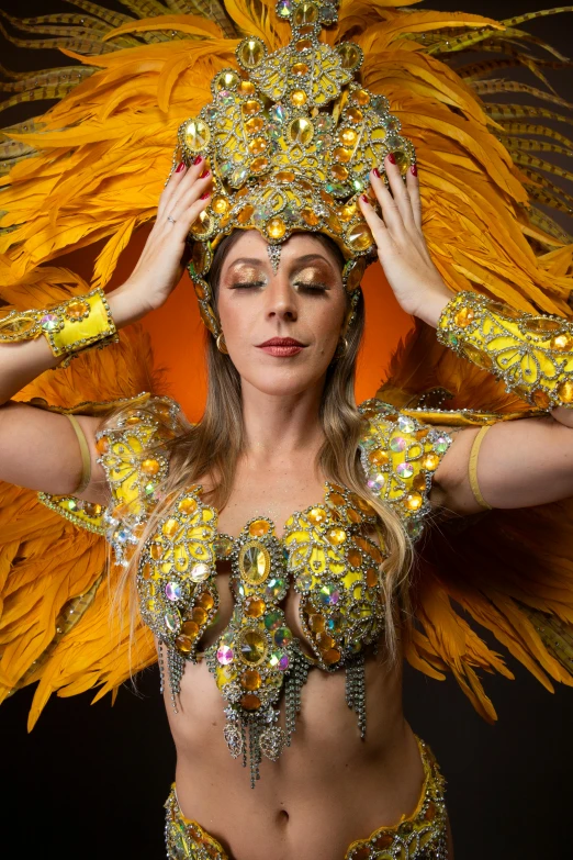 a beautiful woman wearing bright colored costumes and holding her hands on her head