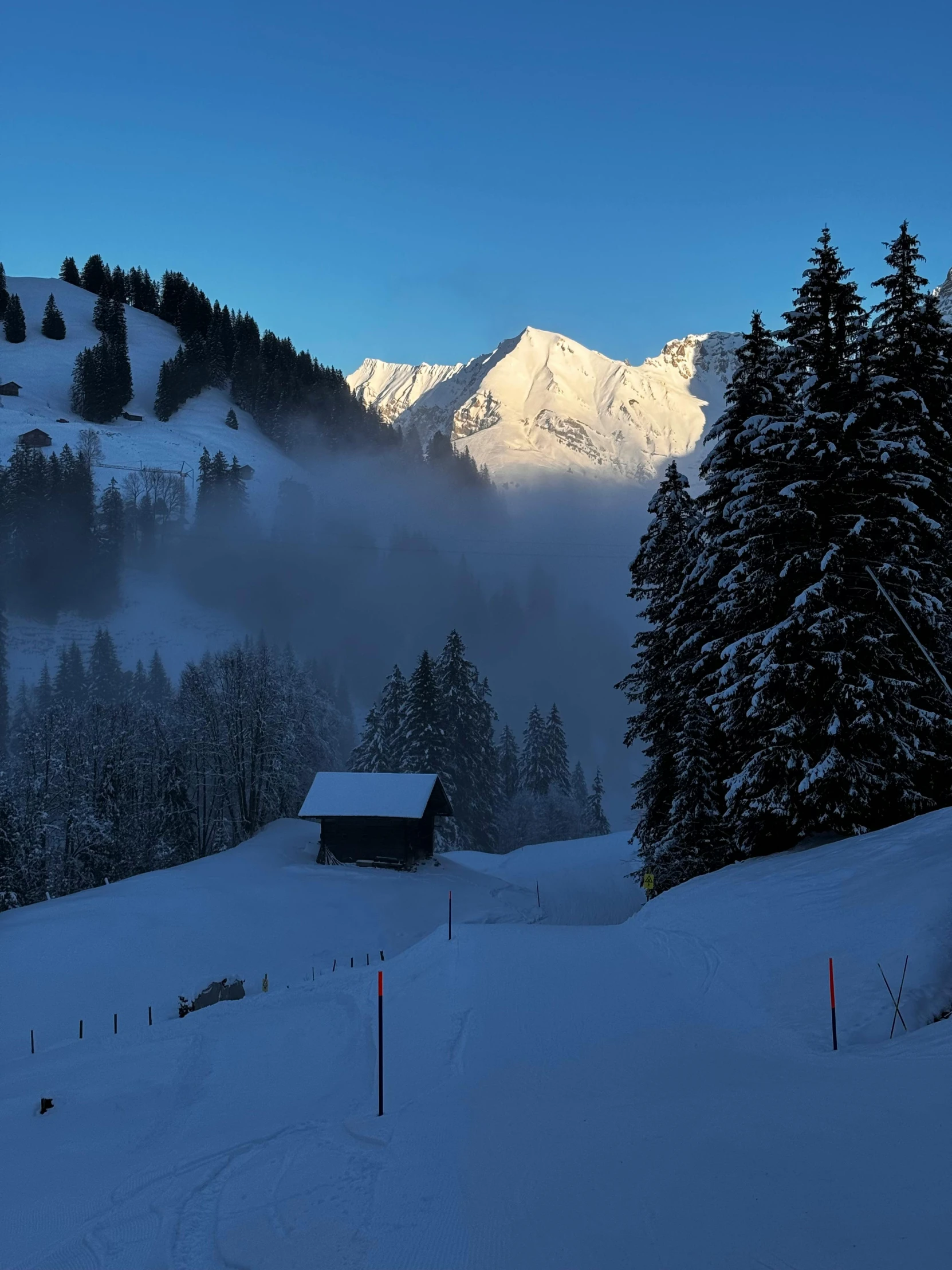 a snow covered mountain with a cabin on top of it