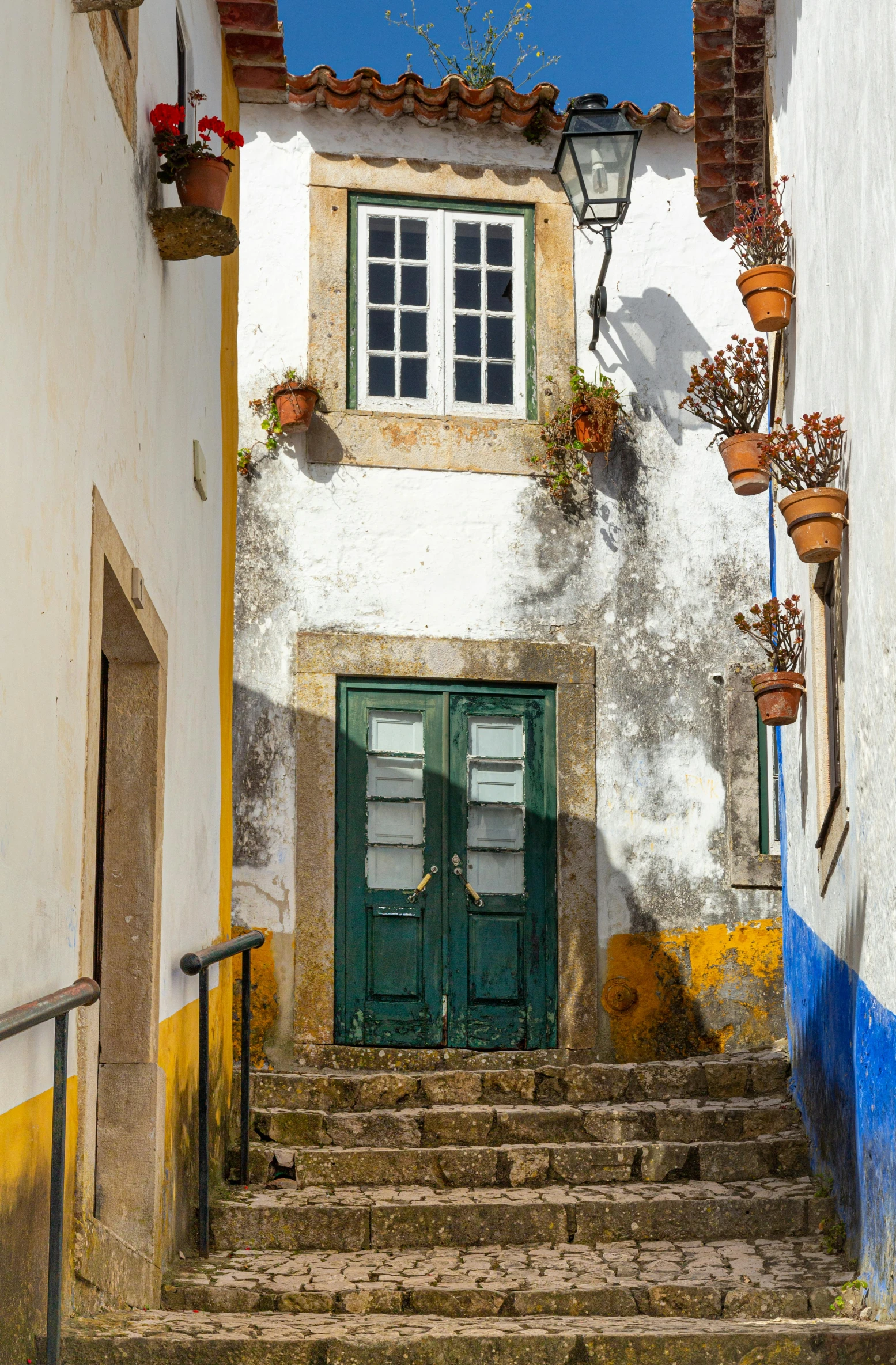 stairs lead down to an entrance door in a colorful town