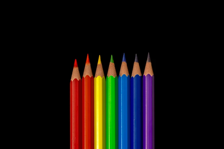 seven rainbow colored pencils stacked close together