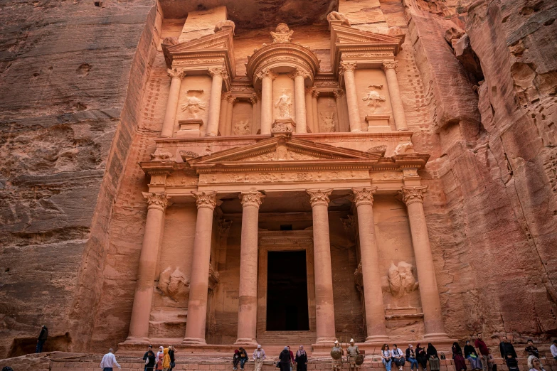 tourists at the entrance to a rock carved building