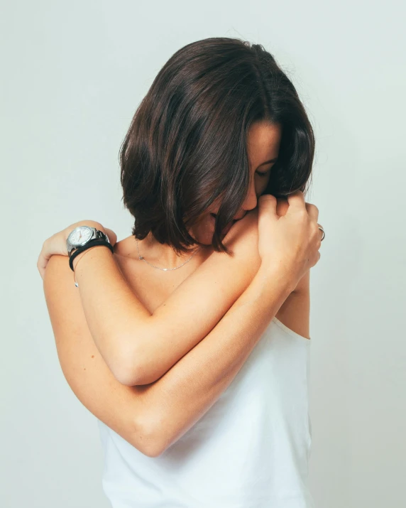 a woman standing in a pose and clutching her arm on one side