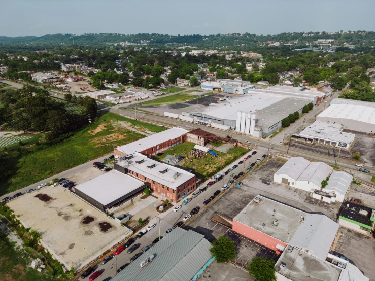 an aerial view of an industrial area with a building, trees, and street