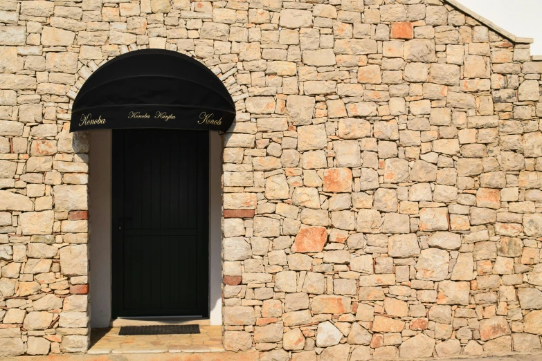 stone building with arched door and bench sitting outside