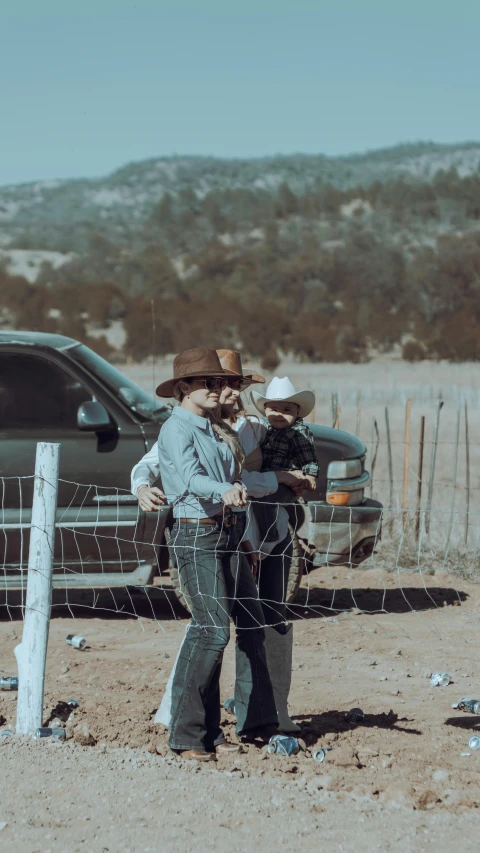 two men in cowboy hats are standing outside