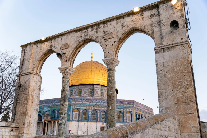 a building with an arch and a dome sitting below it