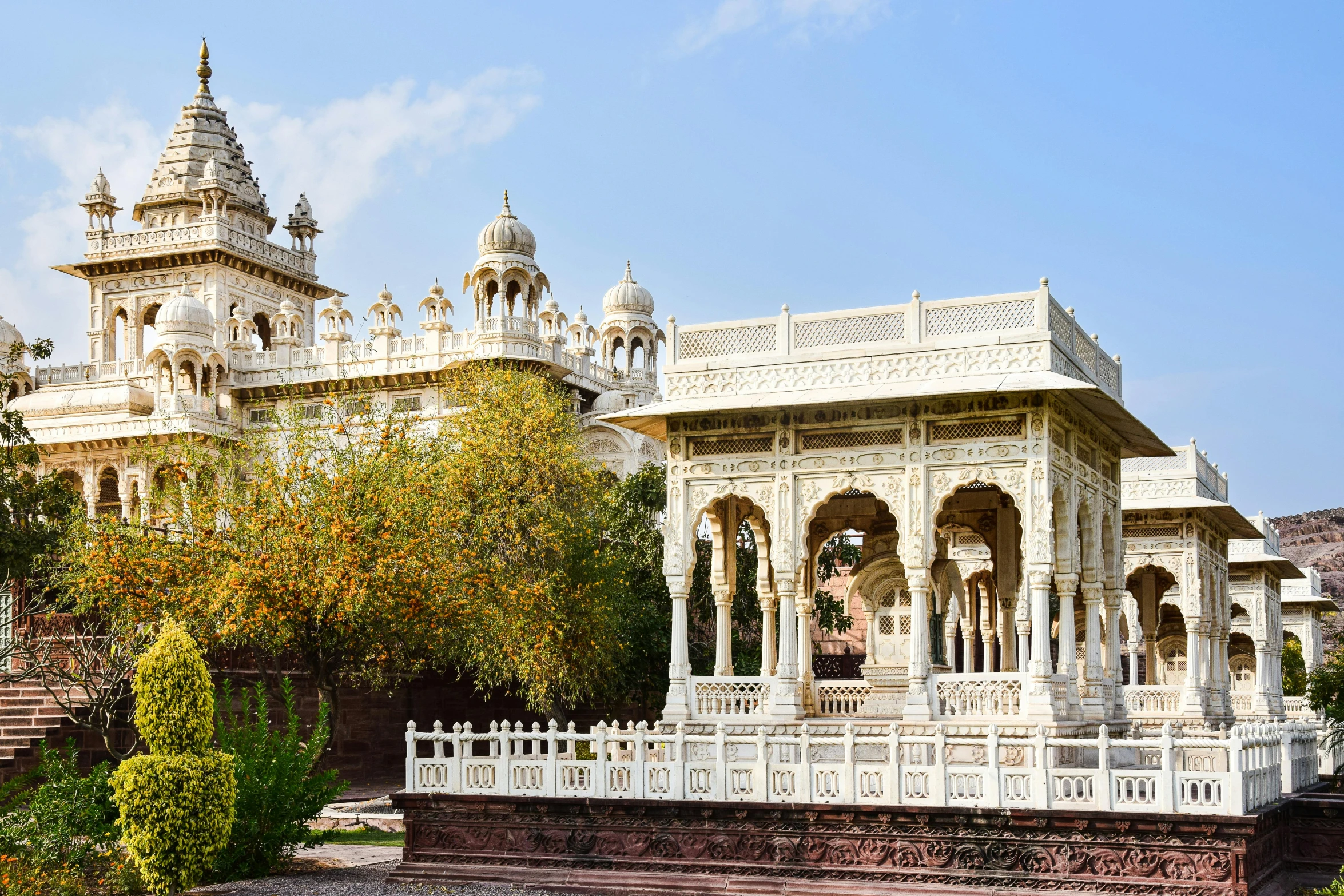 white architecture with pillars and towers set against a cloudy sky