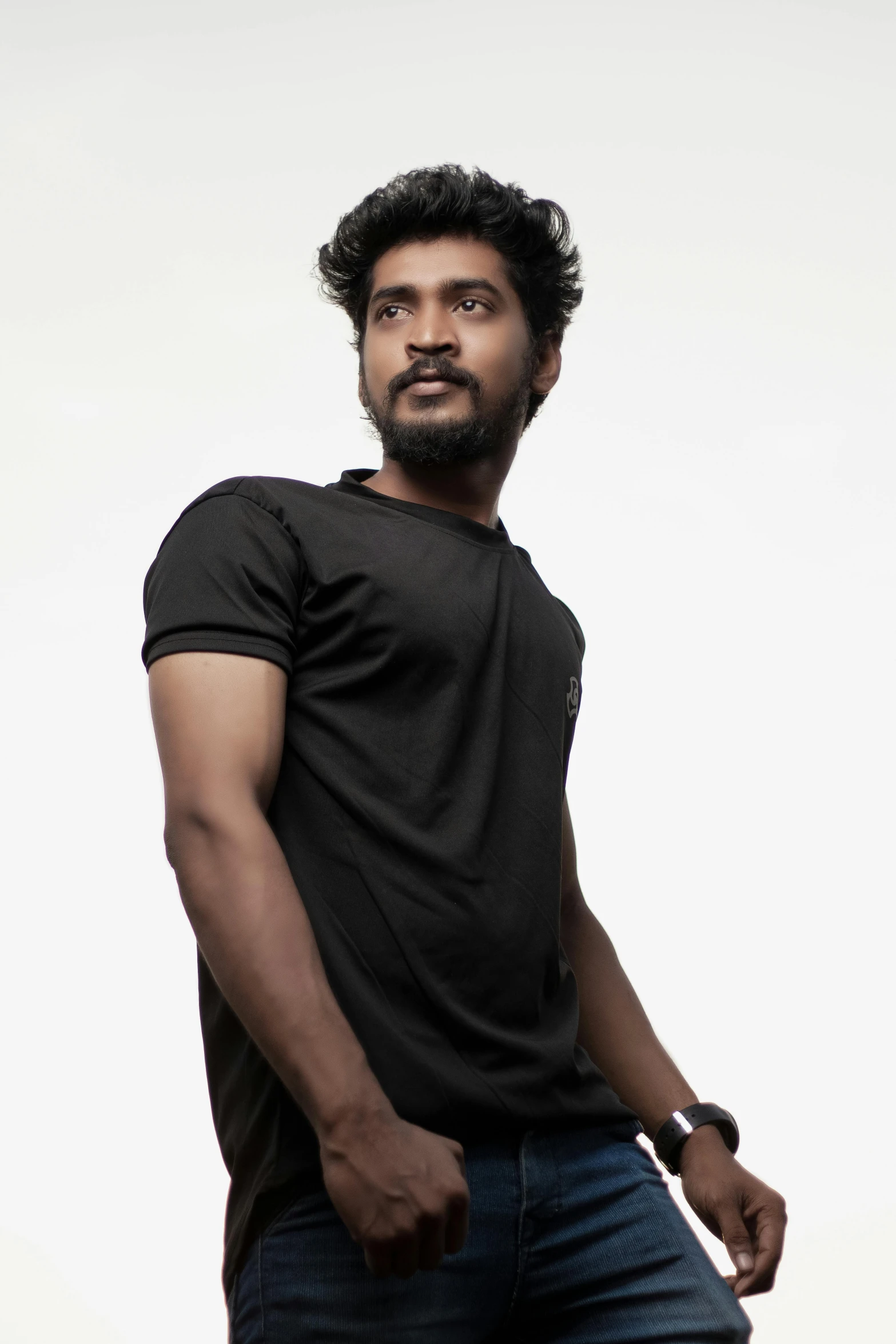 man in black t shirt standing on a white backdrop