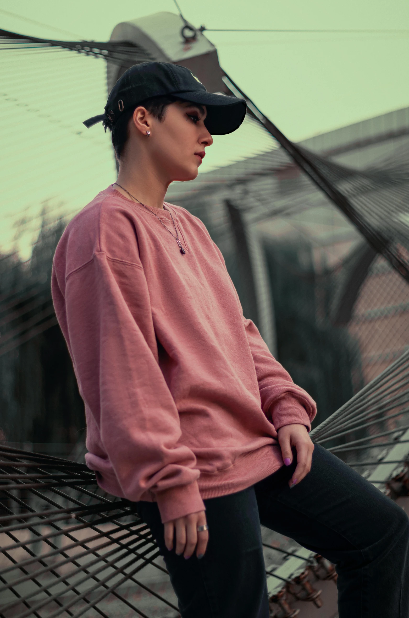 a girl with black hair sitting on top of a hammock