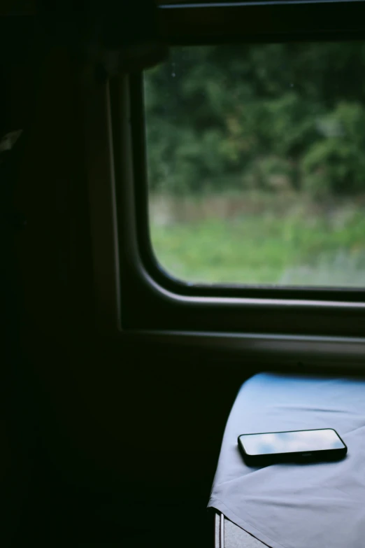 an electronic device is on the table by the window