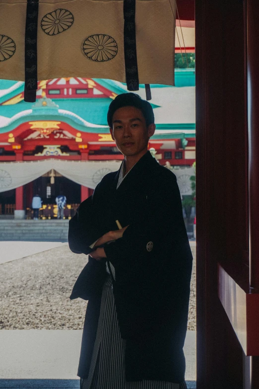 asian woman in a long coat and hat standing outside a building