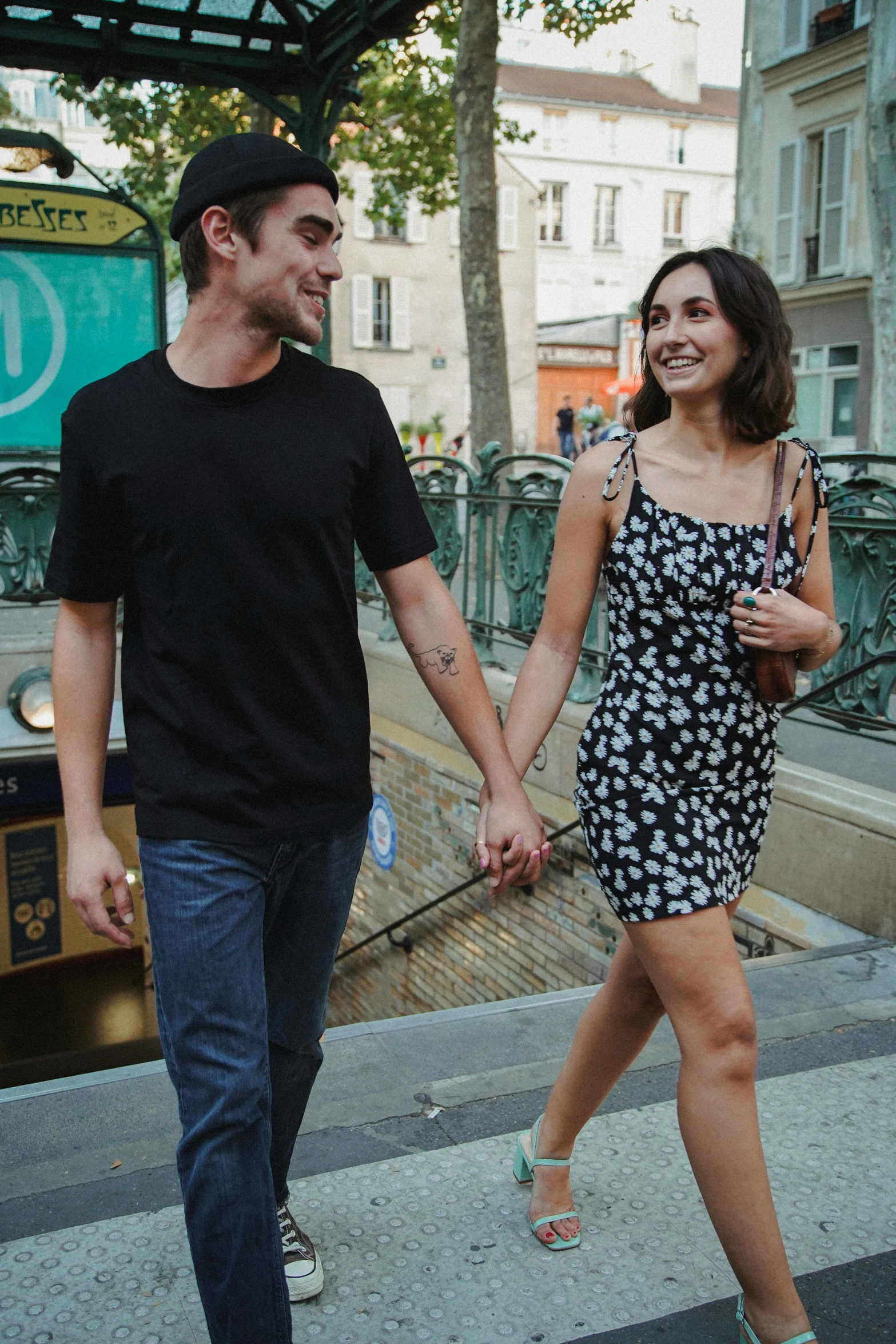 a man and woman holding hands crossing a street