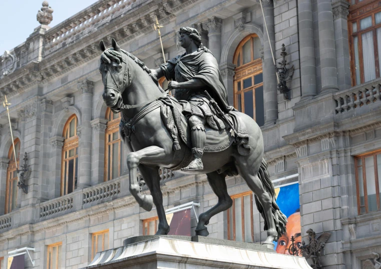 a statue of a man on a horse in front of a building