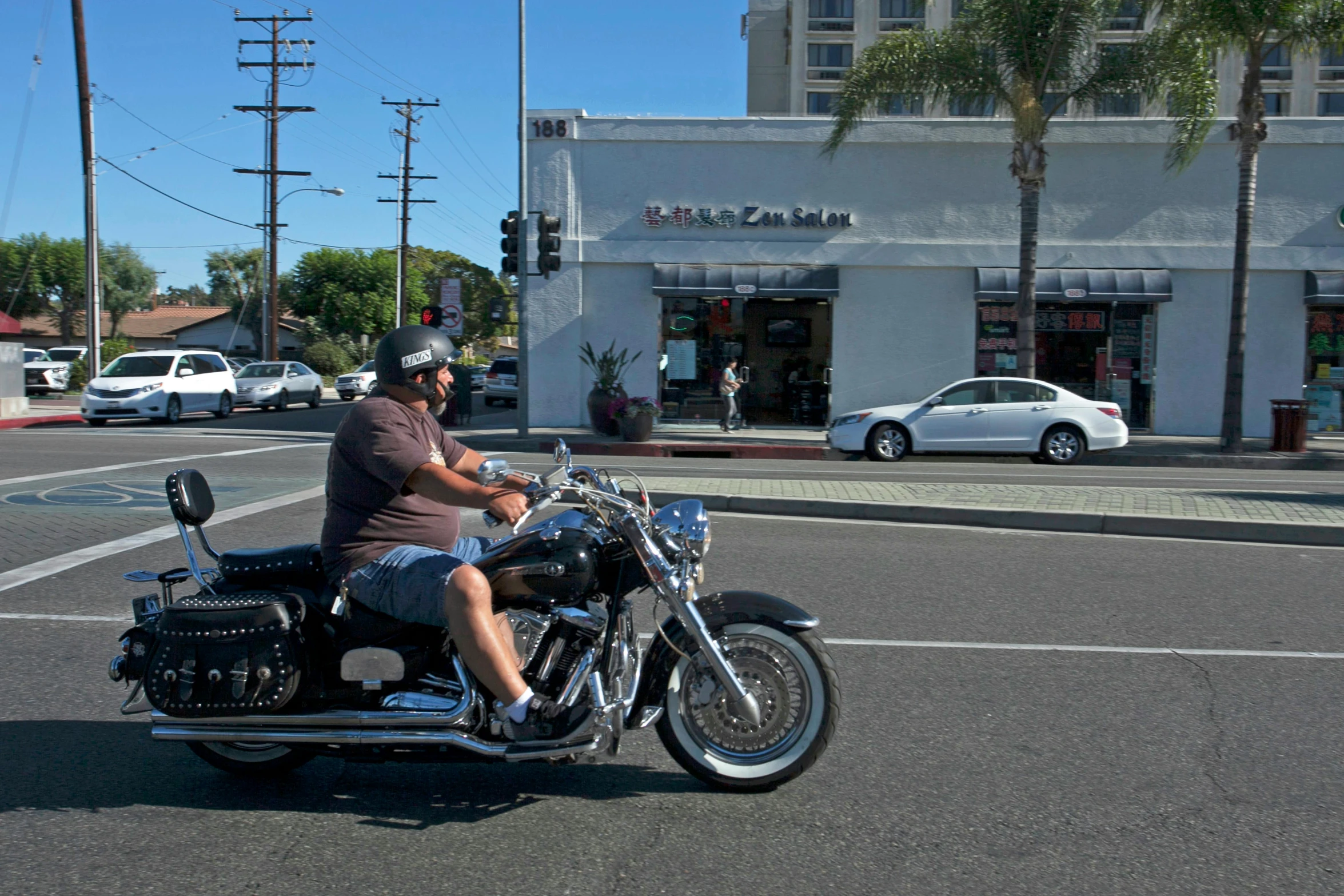 the man is riding his motorcycle in the parking lot