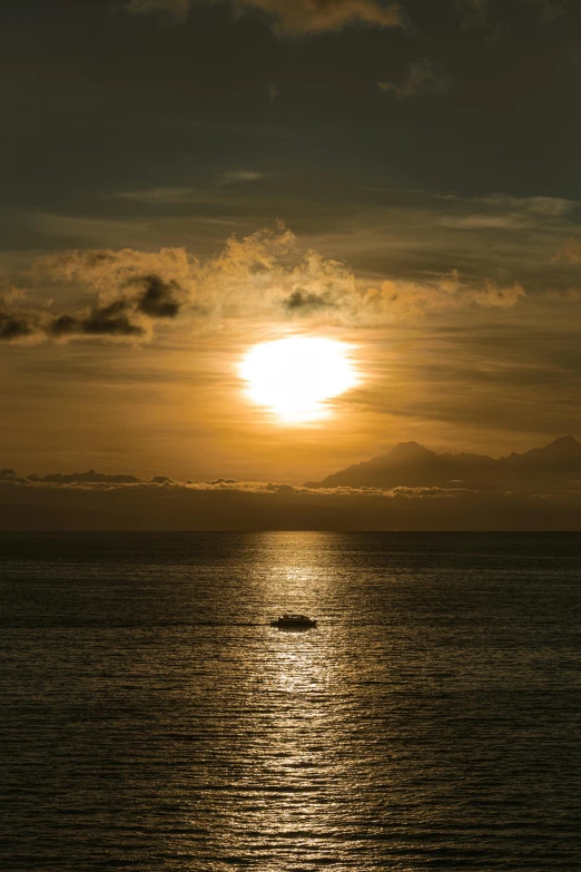 the setting sun reflects in the calm water of a body of water