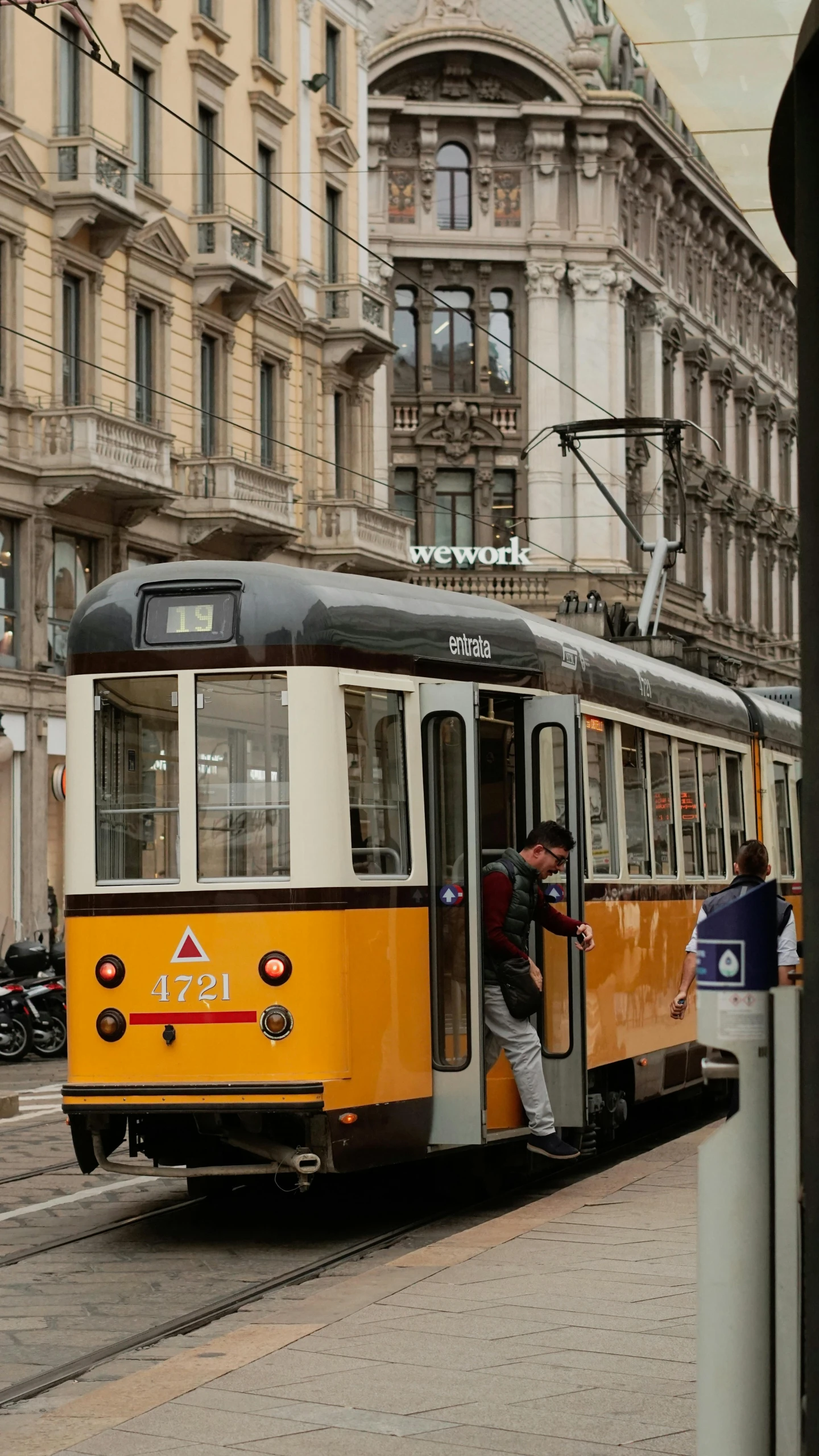 two people are entering and exiting an electric bus