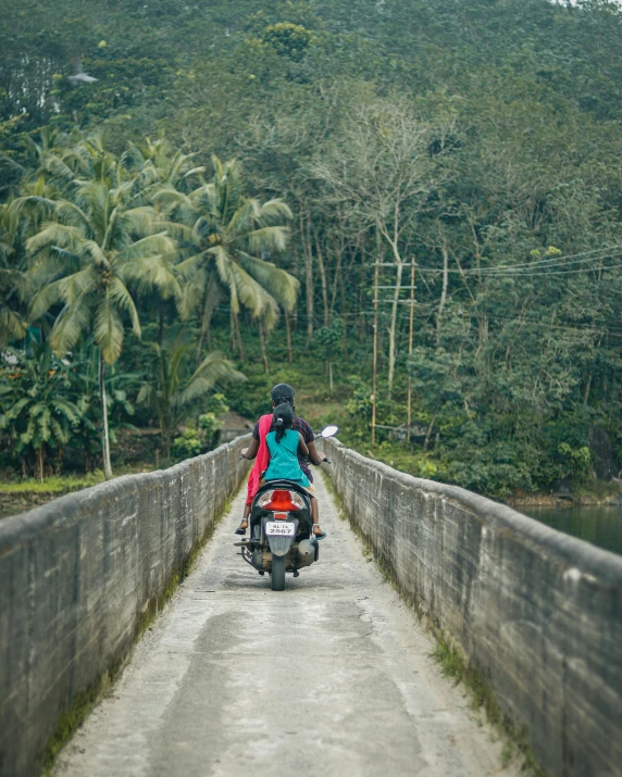 a person riding a motorcycle on top of a bridge