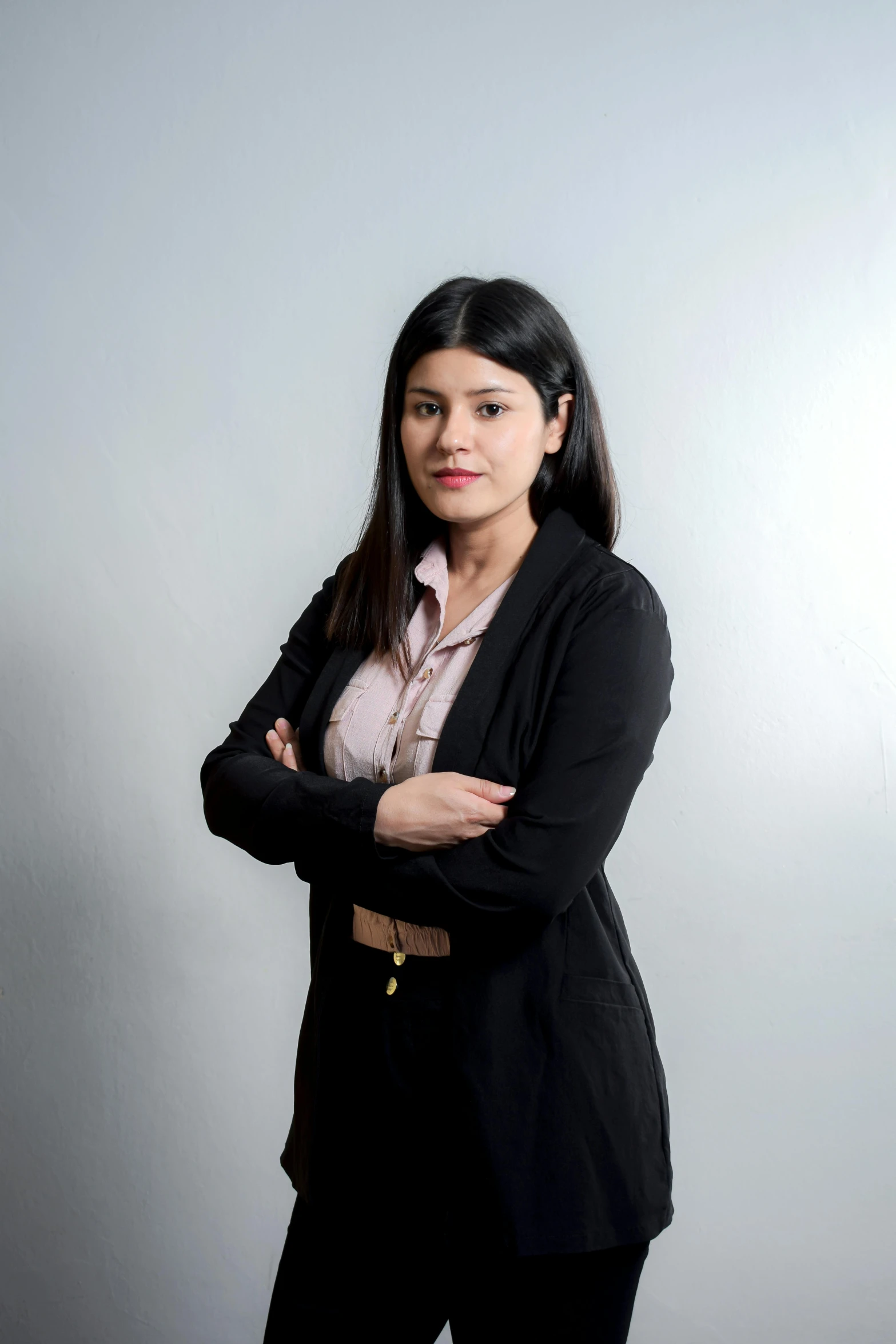 a women who is wearing a suit with her arms crossed