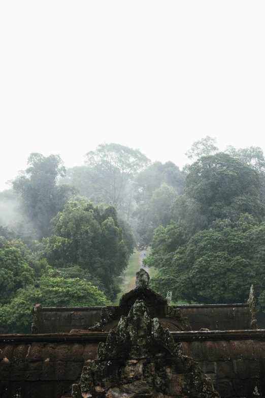 there is a stone fountain in front of trees