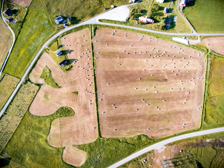 an aerial view of a farm land with several mounds