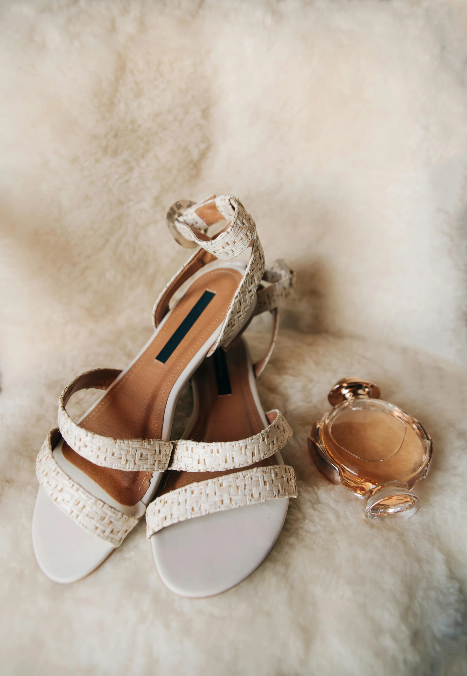 woman's shoes, ring and mirror lying on fur