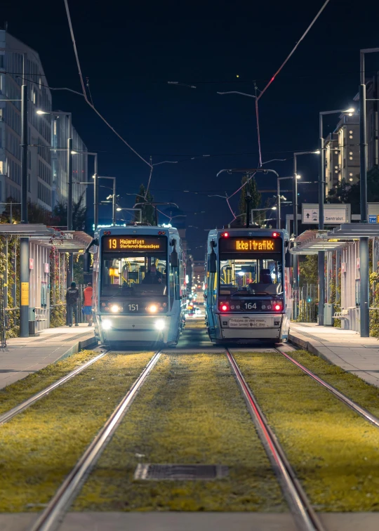 two buses passing each other at night on the street