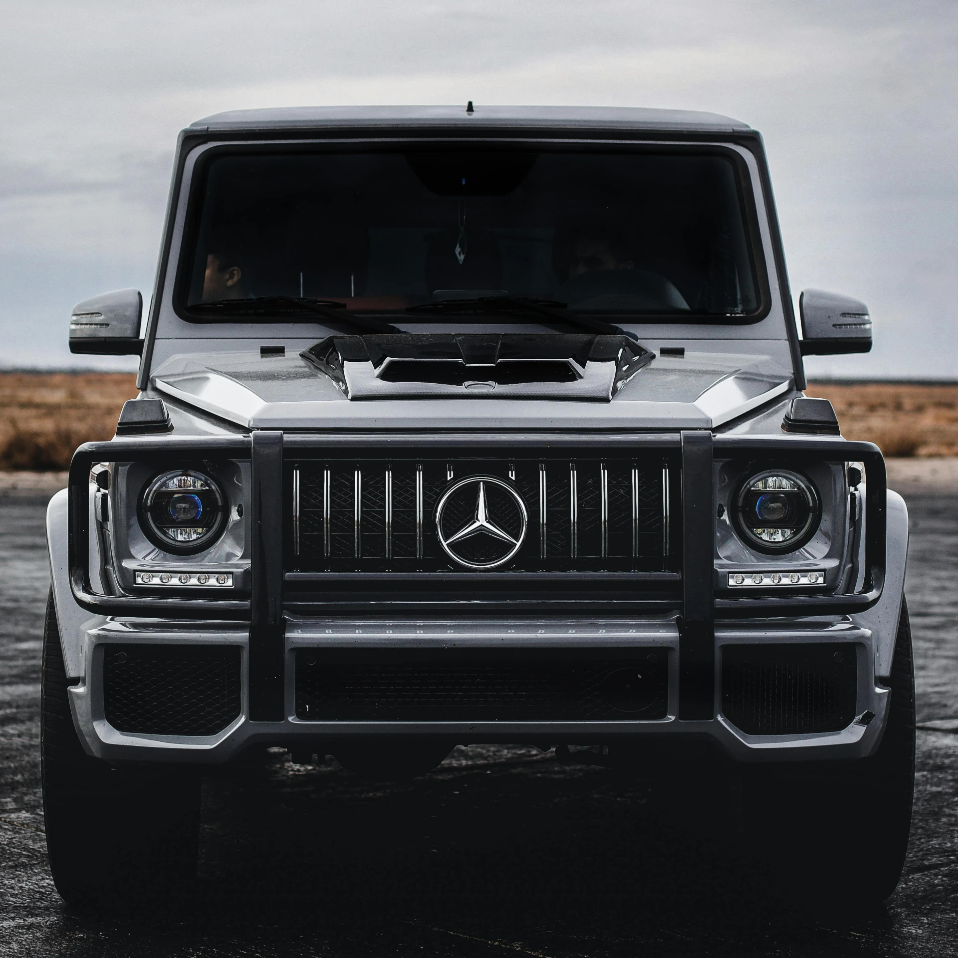 the front view of a mercedes g class in black and white