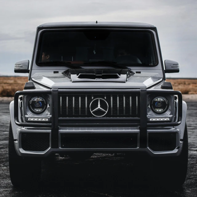 the front view of a mercedes g class in black and white