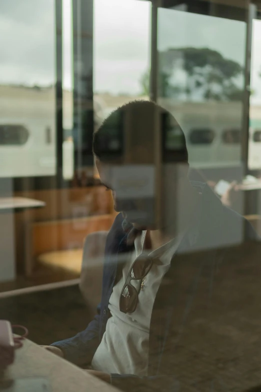 a reflection in a glass shows the front window of a restaurant