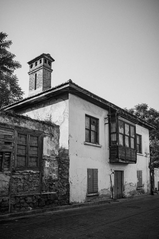 an old house with a stone wall and steeple and a clock tower