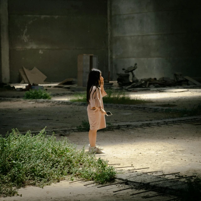 a girl in a pink dress standing in front of a wall