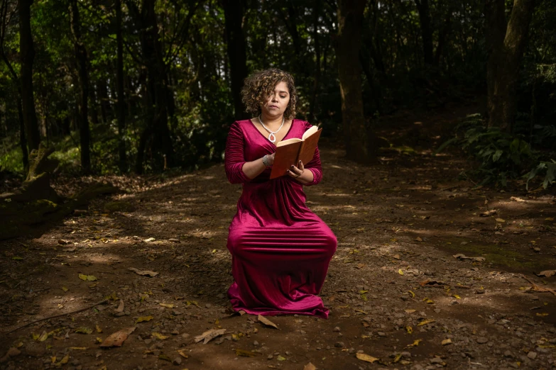 a woman in a red dress standing on the ground with her hands open